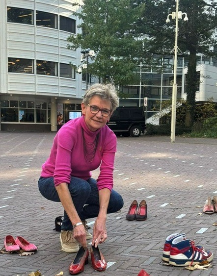 Marian plaatst rode schoenen voor Sandra voor het gebouw van de Tweede Kamer.